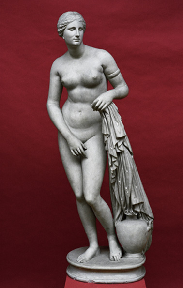 Marble statue of the goddess Aphrodite, nude, standing next to a pot and holding a garment in her left hand.