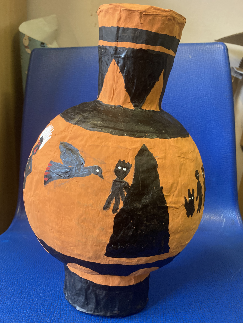 Papiermaché model of a Greek vase in a gorgeous orange and black. Black figures on the vase represent Prometheus chained to Mount Caucasus watching in horror as the Eagle sent by Zeus arrives to peck at his liver.