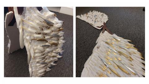 Life-size model of feathered wings, painted gold and silver in places, with straps for wearing. 